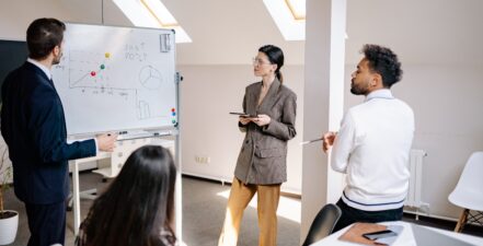 employees-reviewing-whiteboard