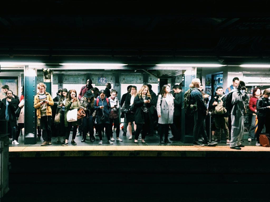 People standing on a crowded subway platform.