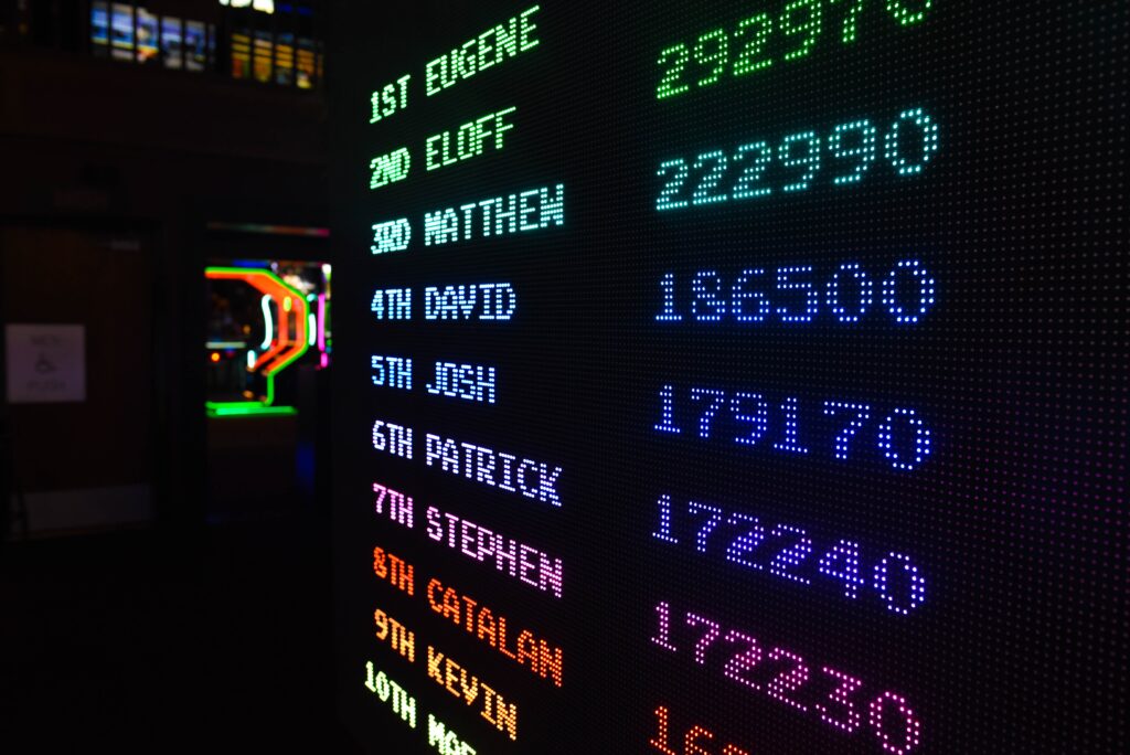 A scoreboard at a gaming center shows the top 10 names and scores.