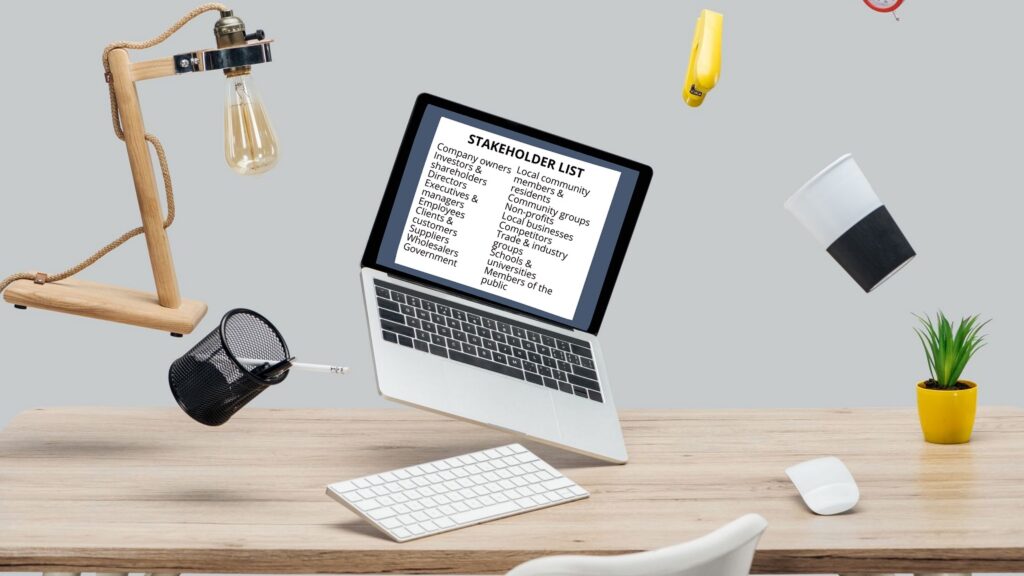 Stylized photo showing items hovering above a desk, including a laptop displaying a stakeholder list.