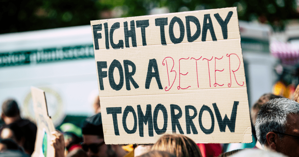 Grassroots campaign participants holding up a sign that says ‘Fight today for a better tomorrow’.