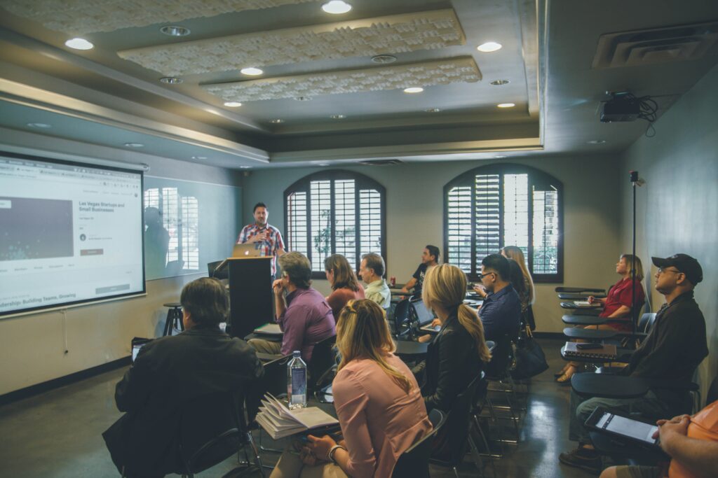 A group of stakeholders gathered in a room and watching a presentation.