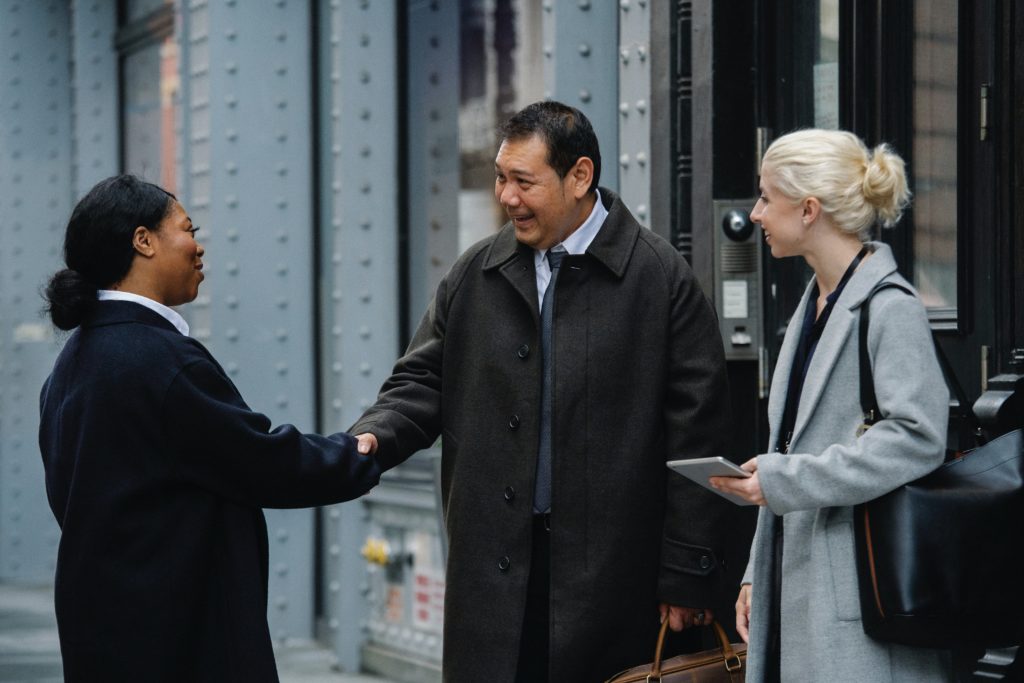 People in corporate clothing shaking hands.