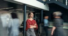 People moving around a young woman who is in focus.
