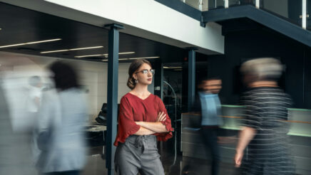People moving around a young woman who is in focus.