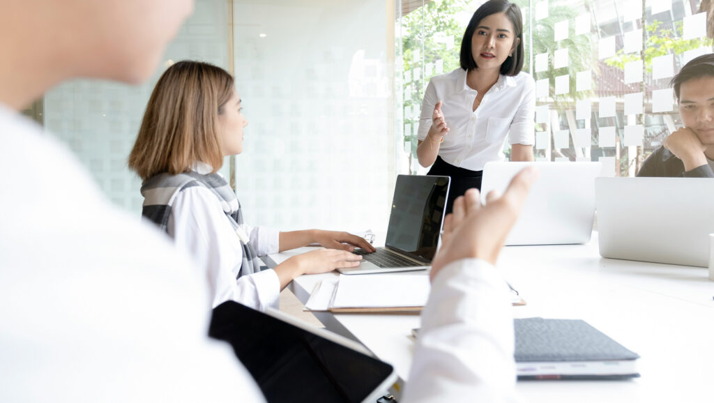 Image of a woman leading a meeting in an office to represent choosing an SRM system owner.