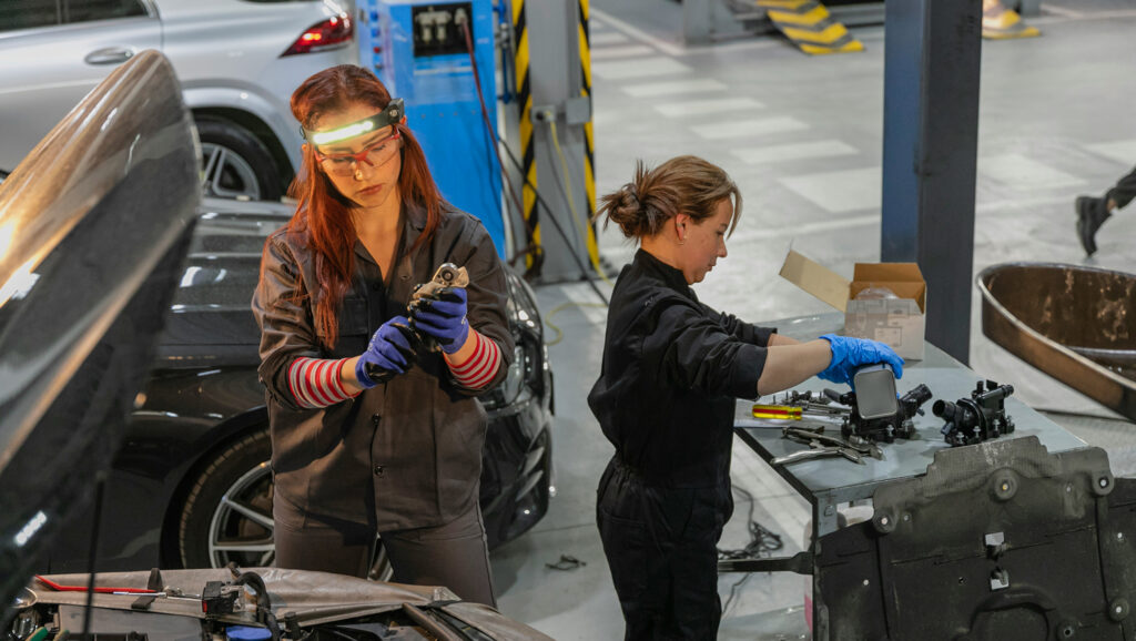 Two women working on car assembly to represent equality in the work place as part of the CSRD materiality assessment. 