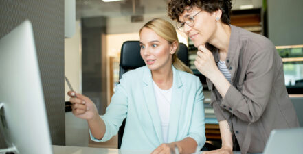Two businesswomen looking at a computer screen. The image represents choosing stakeholder software.